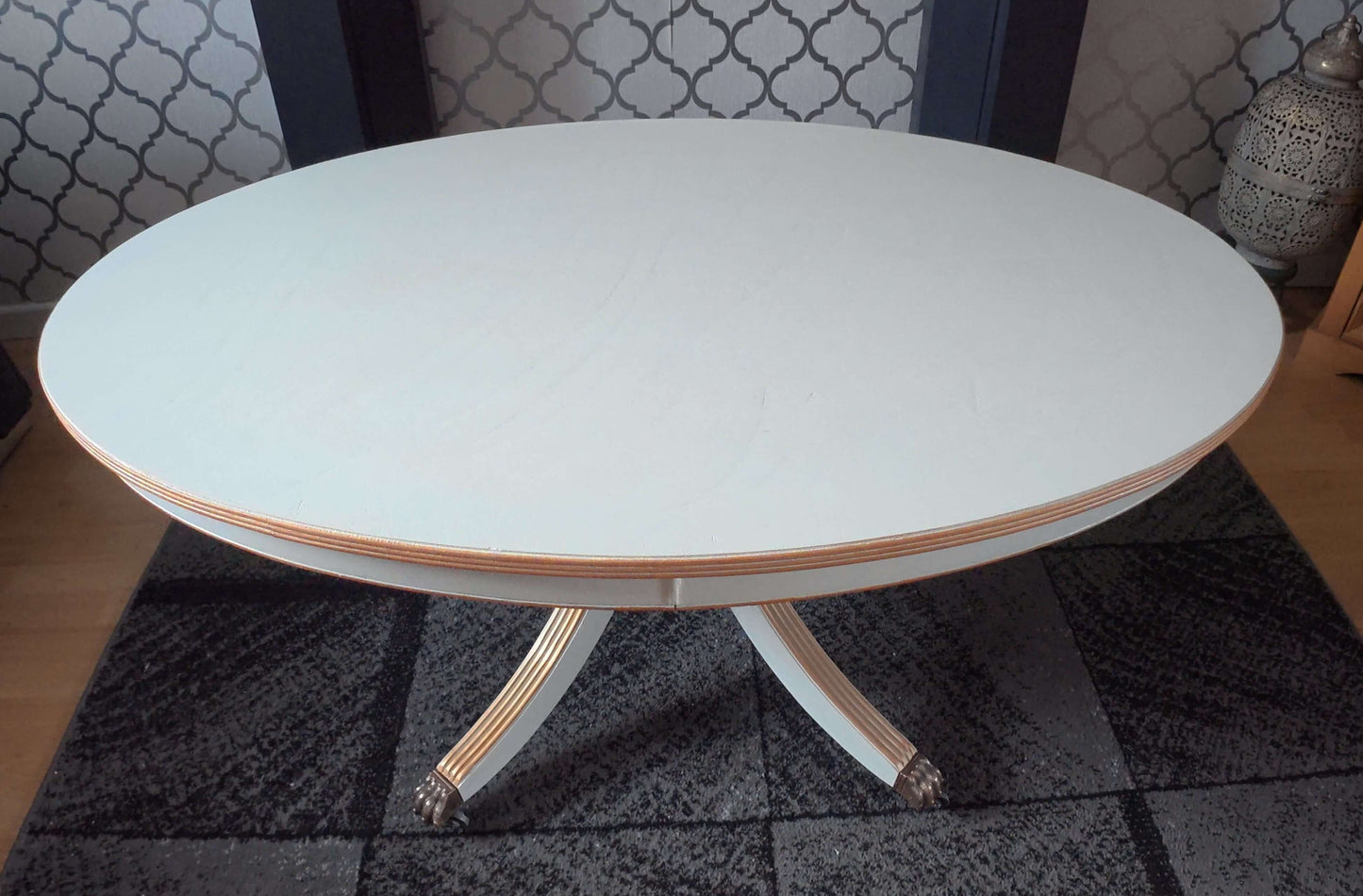Oval white/grey table with gold trim.