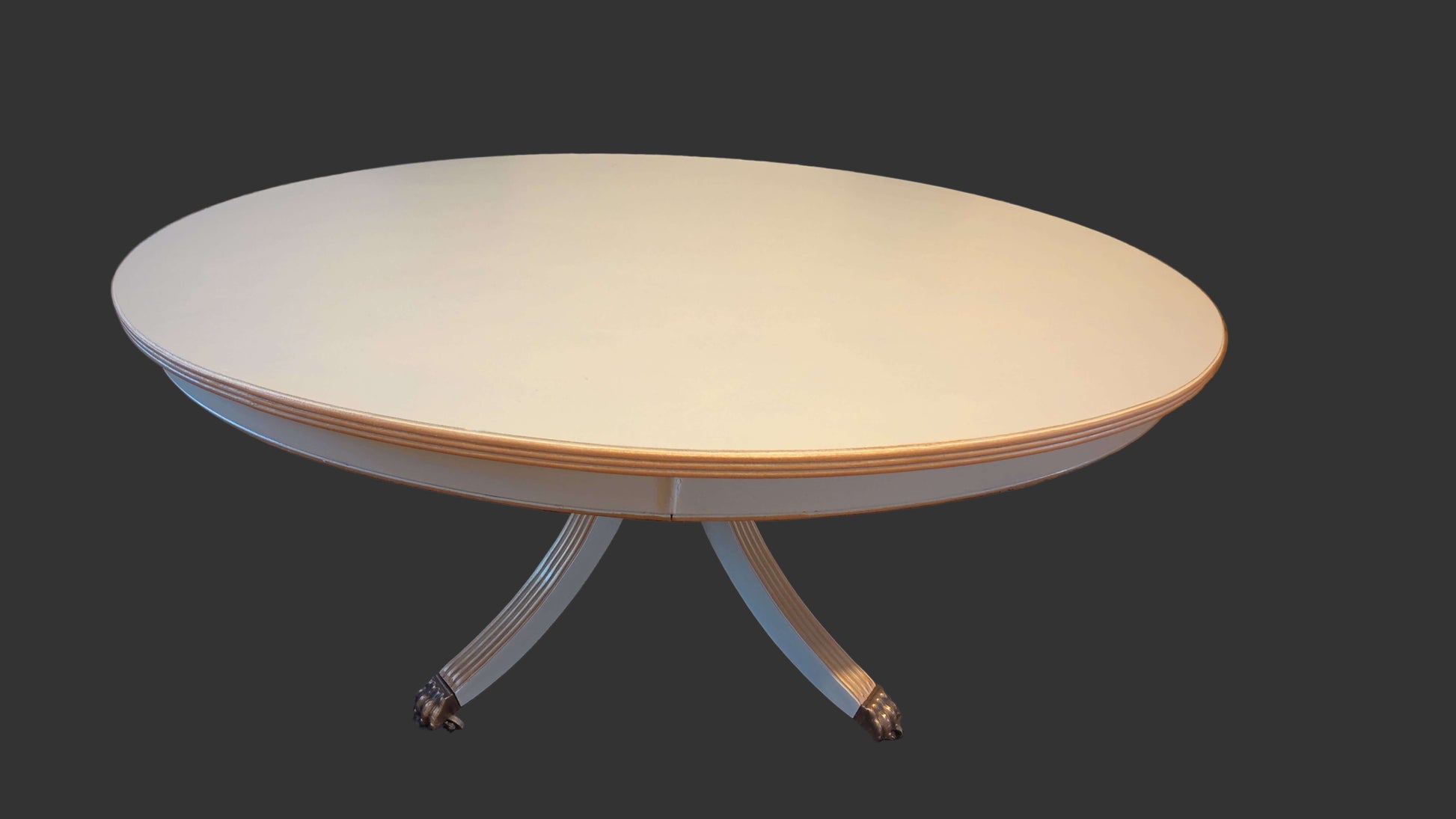 Round table with a light-colored top and white base on a black background